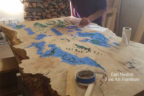 Earl placing turquoise in voids and cracks of cluster burl maple coffee table